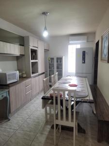 een keuken en eetkamer met een tafel en stoelen bij Casa com 3 Quartos Enseada Encantada in Porto Belo +12 foto's