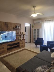 een woonkamer met een grote flatscreen-tv bij Casa com 3 Quartos Enseada Encantada in Porto Belo