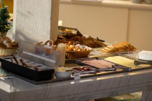 a buffet with bread and pastries on a table at Hotel Portinari Centro in Foz do Iguaçu