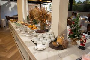 a buffet line with a long table of food at Hotel Portinari Centro in Foz do Iguaçu