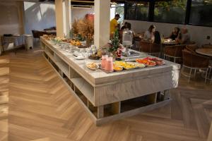 a buffet table with food on it in a restaurant at Hotel Portinari Centro in Foz do Iguaçu