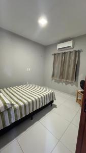 a bedroom with a bed and a air conditioner at Casa de praia Cleo in Luis Correia