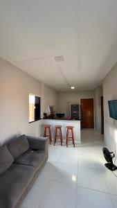 a living room with a couch and a kitchen at Casa de praia Cleo in Luis Correia