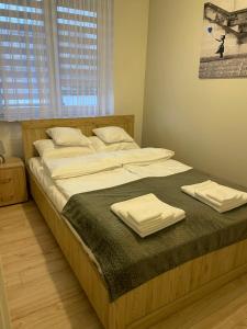 un grande letto con due asciugamani sopra di WhiteHouse a Jarosław