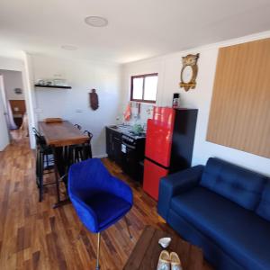 een woonkamer met een blauwe bank en een tafel bij Tiny Tunquen in Valparaíso