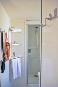 un bagno con doccia con porta in vetro di U Pezzo a Saint-Florent