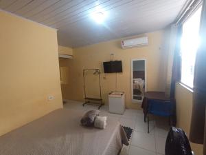 a room with a bed and a television in it at kit Net B in São Luís