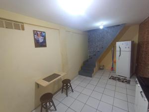 a kitchen with a staircase and two stools and a refrigerator at kit Net B in São Luís +1 photo