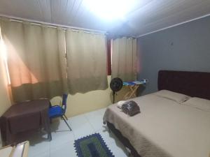 a bedroom with a bed and a chair and a window at kit Net B in São Luís