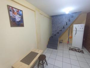 a room with a staircase and a table and a refrigerator at kit Net B in São Luís