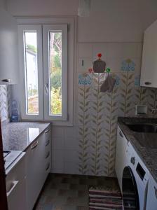a kitchen with a washing machine and a window at Appartamento Cervia in Cervia +1 photo