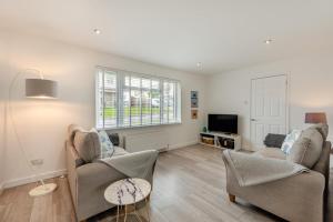 a living room with two chairs and a tv at 3 Bed in Georgeham oc-seashe in Georgeham