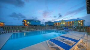 een zwembad met twee stoelen en een huis bij 2 Homes Sleeps 22 2 Private Pools Firepit Steps to Beach Boardwalk Access in Mustang Beach