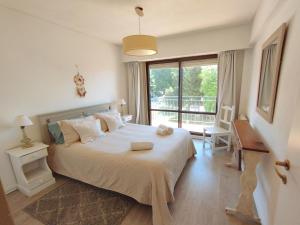 ein Schlafzimmer mit einem großen Bett mit einem großen Fenster in der Unterkunft Cuatro Estaciones in San Carlos de Bariloche