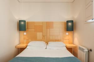 a bedroom with a bed with a wooden headboard at Boavista Guest House in Porto