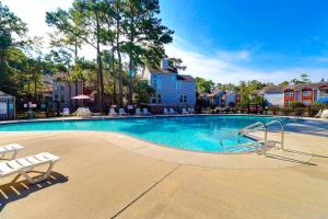une piscine dans un complexe hôtelier avec des chaises longues et des arbres dans l'établissement OYD3 - Las Palmas 2, à Kill Devil Hills