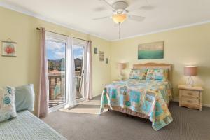 een slaapkamer met een bed en een glazen schuifdeur bij SC1406 - "Beachy" Keen in Kitty Hawk