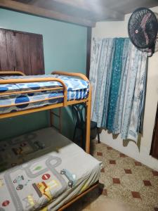 een slaapkamer met 2 stapelbedden en een ventilator bij Hostal Camping Beach in Salinas