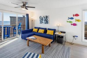 un salon avec un canapé bleu et une table dans l'établissement C323C - Keep On Duckin', à Duck