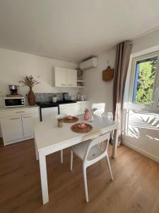 eine Küche mit einem weißen Tisch und einem weißen Tisch sowie ein Zimmer in der Unterkunft Studio au dernier étage d'une bastide grassoise in Grasse