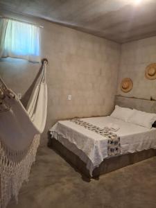 a bedroom with a bed and a hammock at Yahweh Guriú in Camocim