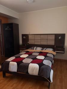 une chambre avec un lit avec une couette noire et blanche dans l'établissement Hospedaje Don Luciano, à San Vicente de Cañete 8 autres photos