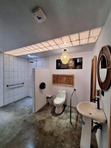 ein Badezimmer mit Toilette und Waschbecken in der Unterkunft Ávita Lodge in Quesada