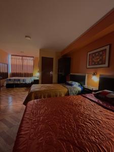 une chambre d'hôtel avec deux lits et une fenêtre dans l'établissement Hospedaje Don Luciano, à San Vicente de Cañete