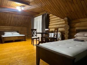 ein Schlafzimmer mit einem Bett, einem Tisch und Stühlen in der Unterkunft Beregynia in Schdenijewo + 124 Fotos