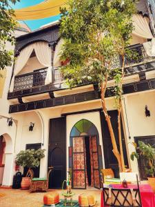 una casa con un albero davanti di Riad ABBASSIA Marrakech Premiere - Authentic Medina Experience a Marrakech