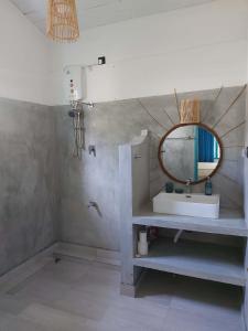 a bathroom with a sink and a mirror on the wall at Amma's Garden in Unawatuna
