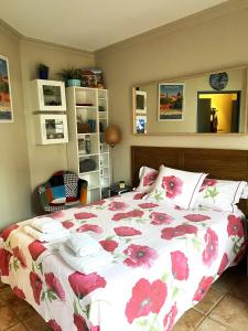 a bedroom with a bed with a floral bedspread at Meublé tourisme Carmes 2 étoiles, entrée autonome,wifi, climatisé, petit parking privé in Toulouse