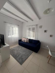 a living room with a blue couch and a tv at Latin House in Funchal