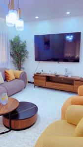 a living room with a large flat screen tv at Yadal Home in Darou Rhamane