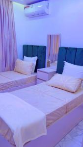 a room with two beds and two chairs at Yadal Home in Darou Rhamane