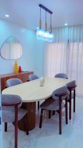 a dining room table with chairs and a light fixture at Yadal Home in Darou Rhamane +8 photos