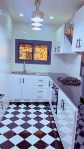 a kitchen with a black and white checkered floor at Yadal Home in Darou Rhamane