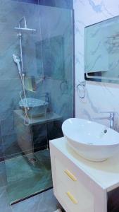 a bathroom with a sink and a glass shower at Yadal Home in Darou Rhamane
