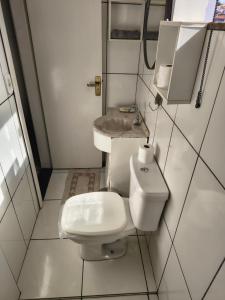 a small bathroom with a toilet and a sink at kitnet Nostradamus in Barão de Cocais