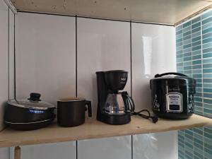 a shelf with various appliances on it in a kitchen at kitnet Nostradamus in Barão de Cocais