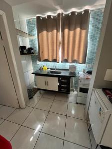 a small kitchen with a sink and a window at kitnet Nostradamus in Barão de Cocais +2 photos