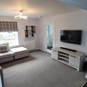 ein Wohnzimmer mit einem großen Flachbildfernseher in der Unterkunft The White House in Elgin
