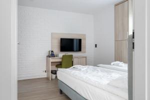 een slaapkamer met een bed, een bureau en een tv bij Aquapark Reda Resort - jedyne noclegi w Aquaparku Reda in Reda