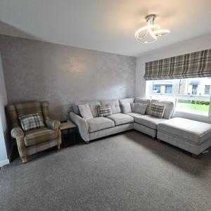 ein Wohnzimmer mit einer Couch und zwei Sesseln in der Unterkunft The White House in Elgin