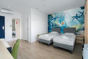 een kamer met twee bedden en een schilderij aan de muur bij Aquapark Reda Resort - jedyne noclegi w Aquaparku Reda in Reda +43 foto's