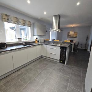 eine Küche mit weißen Schränken und einem Herd mit Backofen in der Unterkunft The White House in Elgin