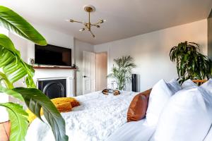 Schlafzimmer mit einem Bett mit Kamin und Pflanzen in der Unterkunft Downtown Columbus & Short North 2BR Home - Sleeps up to 10 Guests - By Convention Center & Nationwide Arena - Free Parking - Over 5,800 Five Star Stays - Casita Verde by Jungle House in Columbus