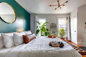ein Schlafzimmer mit einem großen weißen Bett und einer grünen Wand in der Unterkunft Downtown Columbus & Short North 2BR Home - Sleeps up to 10 Guests - By Convention Center & Nationwide Arena - Free Parking - Over 5,800 Five Star Stays - Casita Verde by Jungle House in Columbus