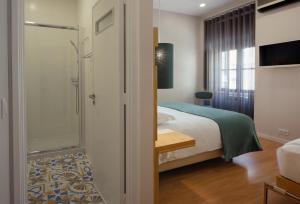 a hotel room with a bed and a shower at Boavista Guest House in Porto
