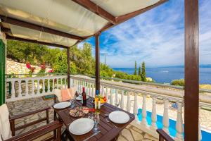 a table on a balcony with a view of the ocean at Villa Anastasia in Ieromónachos
